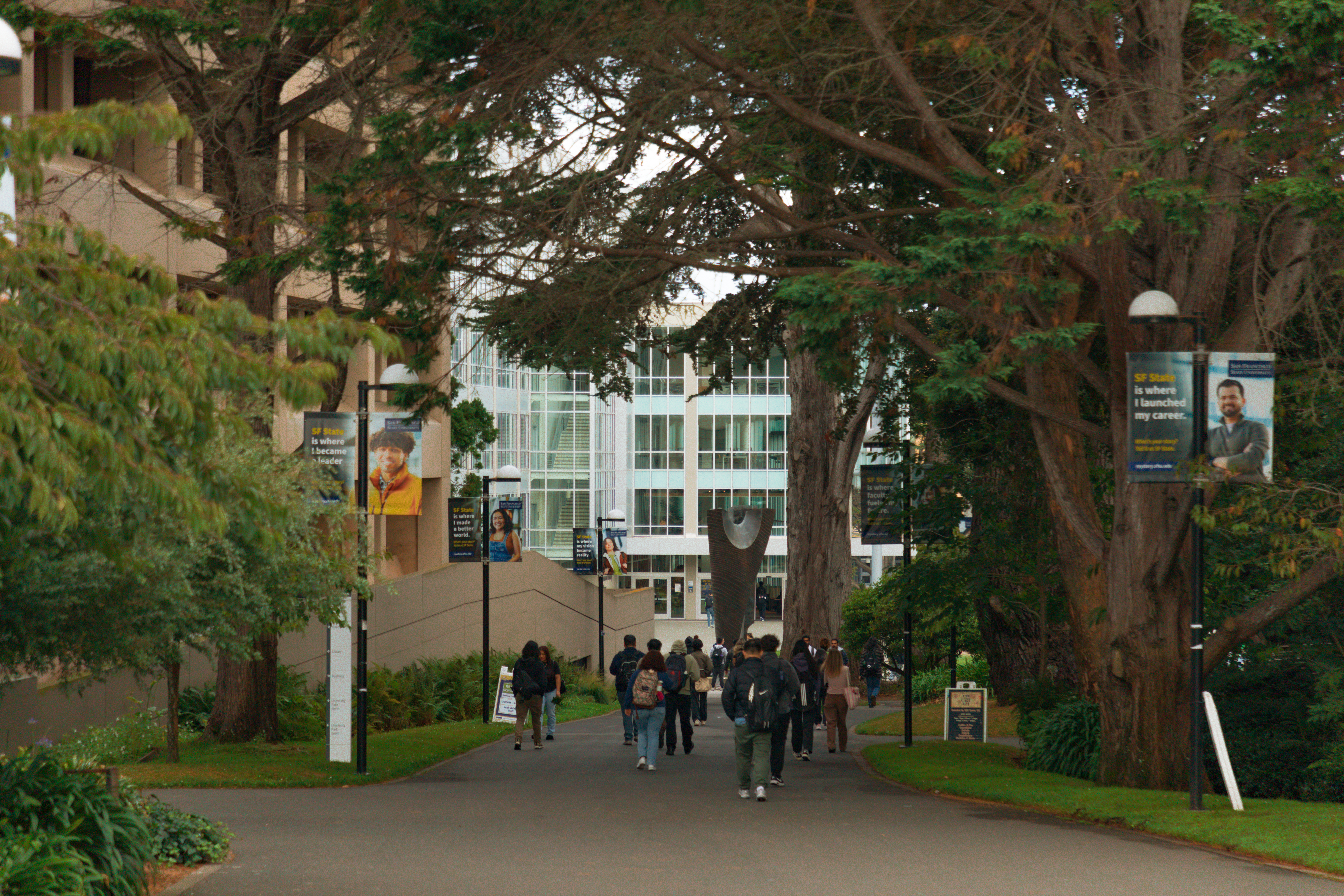 Students walking into campus from the main entrance.