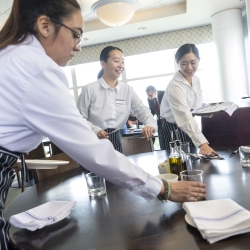 Student waitresses set the table in the restaurant.